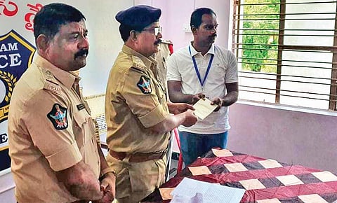 Podili DSP K Prakasa Rao presents a reward to technical assistant Bharat Kumar for playing a key role in tracking the movement of missing children | EXPRESS