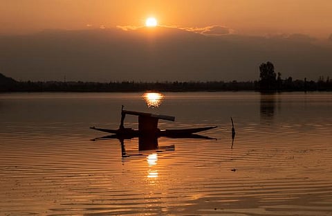 A boat is anchored on the middle of the Dal Lake as the sun sets on a cold day in Srinagar. (Photo | AP)