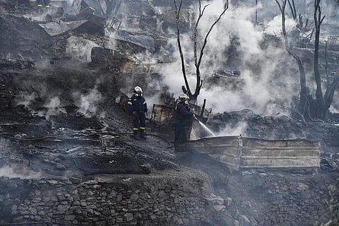 Firefighters spray water inside a refugee and migrant camp after a fire broke out, on the Greek island of Samos, Greece. (Photo | AP)
