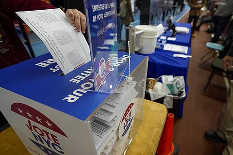 A voter drops an absentee ballot in a locked ballot box during early voting in New York. (Photo | AP)
