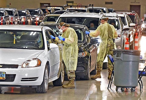 North Dakota National Guard soldiers Spc. Samantha Crabbe, left, and Master Sgt. Melanie Vincent administer COVID-19 tests inside the Bismarck Events Center in Bismarck, N.D.  (Photo | AP)