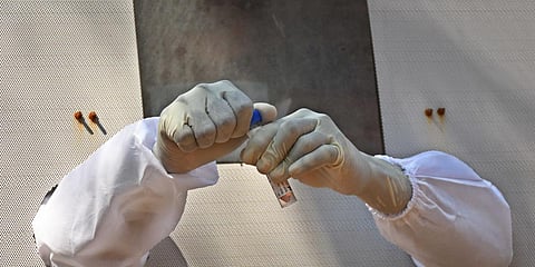 Health worker carefully seals the cap of VTM after collecting sample for ccoronavirus at IGMC Stadium in Vijayawada on Saturday.  (Photo | EPS/Prasant Madugula)