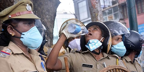 A Kerala cop quenching her thirst while on duty in front of the Secretariat (Photo | Vincent Pulickal, EPS)