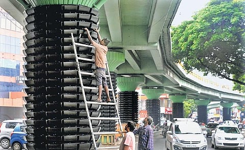 Workers busy installing plastic containers on the piers under Adyar bridge for setting up vertical gardens, in Chennai, on Monday | DEBADATTA MALLICK