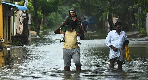 People make their way out of the homes on flooded road in Ram Nagar, Velachery, Chennai. (Photo | EPS/Ashwin prasath)