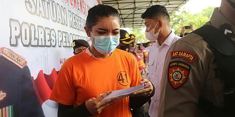 Instagram celebrity Millen Cyrus (C) is escorted by Indonesian police. (File photo| AP)