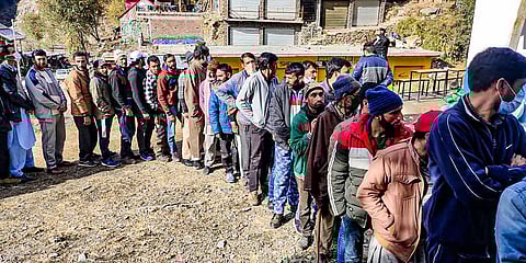 Voters stand in a queue as they wait to cast their votes for the District Development Council elections, at a polling station in Poonch district, Saturday, Nov. 28, 2020. (Photo | PTI)