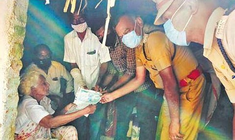 DSP S Radhakrishnan, in the presence of other police personnel, hands over the new land document to Krishnaveniammal at her place | Express