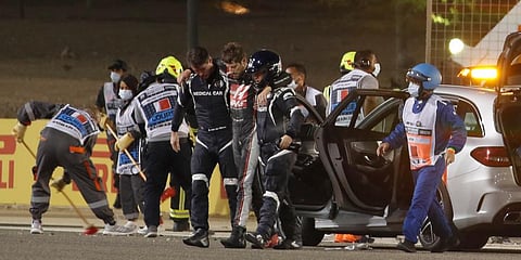 Haas driver Romain Grosjean is helped by medical staff after he crashed his car during the Formula One race in Bahrain International Circuit in Sakhir. (Photo | AP)
