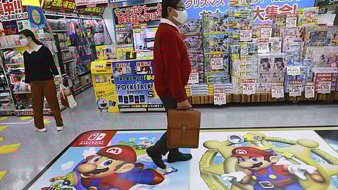 A shopper passes by an ad for Super Mario of Nintendo at an electronics store in Tokyo