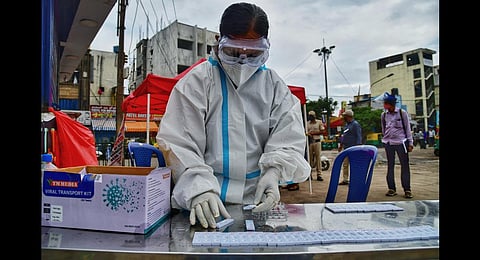 A health worker at a BBMP sample collection kiosk in Bengaluru. (Photo | Shriram BN