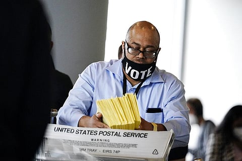 A election worker hands out ballots to be counted at State Farm Arena on Thursday, Nov. 5, 2020, in Atlanta. (Photo | AP)