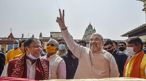 Union Home Minister Amit Shah flashes a victory sign during his visit at Dakshineswar Kali Temple in Kolkata Friday. (Photo | PTI)