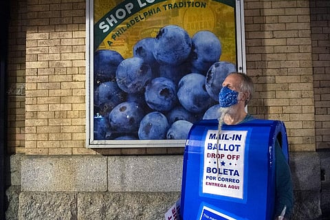 Rolf Sturm, an advocate for getting the vote out, stands dressed as a mailbox during a rally in support of counting the vote outside the Pennsylvania Convention Center Friday, Nov. 6, 2020 in Philadel