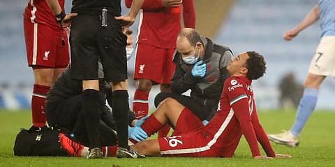 Liverpool defender Trent Alexander-Arnold is assisted after getting injured during the EPL match against Manchester City at the Etihad stadium. (Photo | AP)