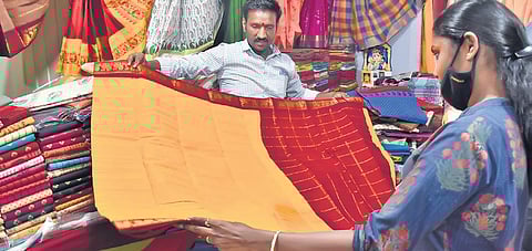 T A Kumaran, a weaver from Paramakudi, displaying the saree woven by blending bamboo and cotton yarns, at the Poompuhar showroom | U RAKESH KUMAR