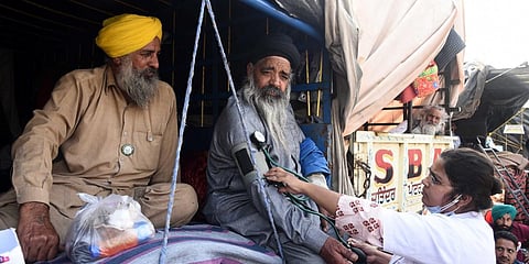 A doctor examines a farmer during their ongoing protests against the new farm laws at Delhi's Singhu border on Thursday. (Photo | Parveen Negi, EPS)