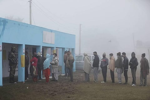 Voters stand in a queue to cast their votes for the sixth phase of District Development Council DDC election at Arnia village in Jammu Sunday Dec. 13 2020. (Photo | PTI)