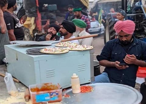 Around 400 pizzas were distributed within minutes as a huge crowd, including the protesting peasants and residents from nearby areas, queued up. (Photo | Twitter)