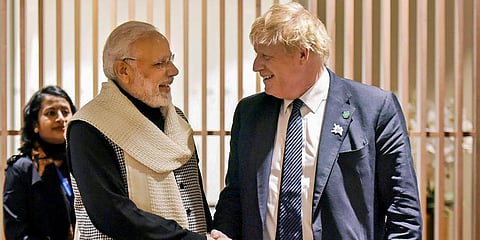PM Narendra Modi shakes hands with British PM Boris Johnson in London. (Photo | PTI)