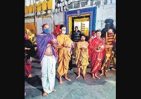 Servitors holding earthen lamps in front of Haribaldevjew temple on Tuesday