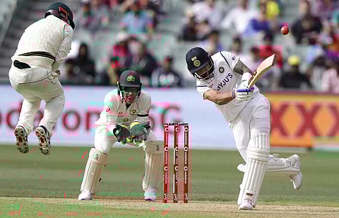 India's Virat Kohli, right, drives the ball as Australia's Travis Head, left, jumps in anticipation during their cricket test match at the Adelaide Oval in Adelaide, Australia. (Photo | AP)