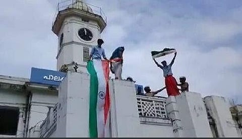 A group of DYFI activists rolling down the national flag from atop the Municipal office building in Palakkad on Friday. (Photo | EPS)