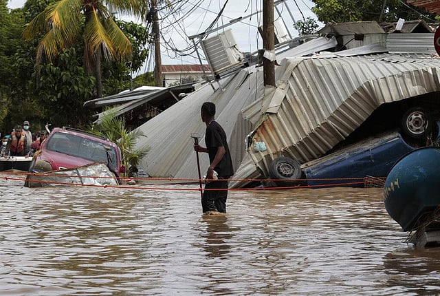 In this November 6, 2020, a resident walking through a flooded street looks back at storm damage caused by Hurricane Eta in Planeta, Honduras. As Eta moved back over Caribbean waters, governments in Central America worked to tally the displaced and dead, and recover bodies from landslides and flooding that claimed dozens of lives from Guatemala to Panama. This year has seen record Atlantic hurricanes and western wildfires, devastating floods in Asia and Africa and a hot, melting Arctic. It's not just been a disastrous year, but a year of disasters. (Photo | AP)