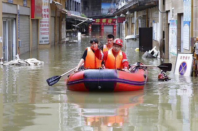 In this August 18, 2020, rescuers use an inflatable boat as they evacuate people from a flooded neighborhood in Neijiang in southwestern China's Sichuan Province. This year has seen record Atlantic hurricanes and western wildfires, devastating floods in Asia and Africa and a hot, melting Arctic. It's not just been a disastrous year, but a year of disasters. (Photo | AP)