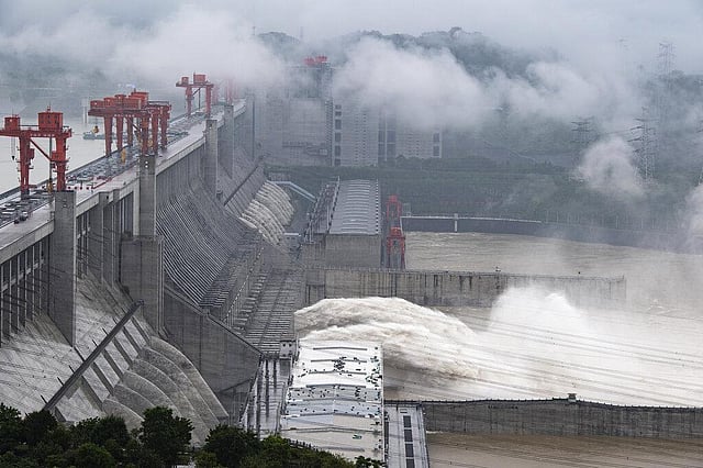 In this July 17, 2020, water flows out from sluiceways at the Three Gorges Dam on the Yangtze River near Yichang in central China's Hubei Province. Engorged with heavy rains, China's mighty Yangtze River crested again in July, as destructive seasonal floods have grown in force since June. This year has seen record Atlantic hurricanes and western wildfires, devastating floods in Asia and Africa and a hot, melting Arctic. It's not just been a disastrous year, but a year of disasters. (Photo | AP)