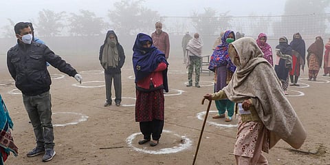 Voters stand in queues to cast their votes for the last phase of DDC elections at Pragwal village in Akhnoor Jammu Saturday Dec. 19 2020. (Photo | PTI)