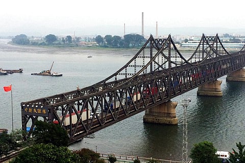 Trucks cross the friendship bridge connecting China and North Korea in the Chinese border town of Dandong, opposite side of the North Korean town of Sinuiju. (File Photo | AP)