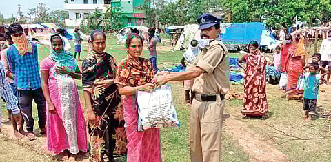 Head constable K Krishna Murty distributing clothes and essentials to the poor at Parvatipuram in Vizianagaram. (Photo | Express)