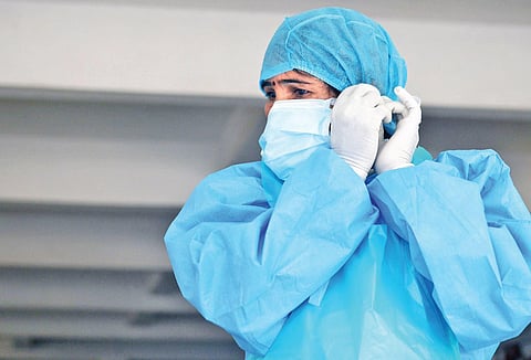 A technician gets ready to resume testing after her lunch break at a fever clinic in Bengaluru on Saturday | Meghana Sastry
