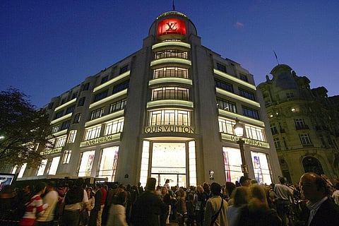 In this Oct. 9, 2005, file photo, a crowd gathers in front of French luxury goods maker Louis Vuitton's landmark store on the Champs Elysees in Paris, during its reopening ceremony. (Photo | AP)