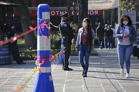 police officer guards the entrance to a park closed due to the new coronavirus restrictions in Mexico City, Sunday, Dec. 20, 2020. (Photo | AP)