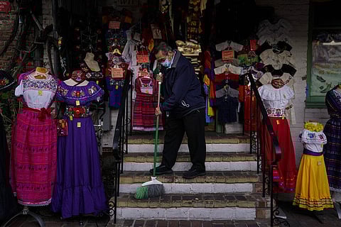 Victor Flores, 66, a third-generation owner of a gift shop, sweeps the steps of his store on Olvera Street in downtown Los Angeles (Photo | AP)