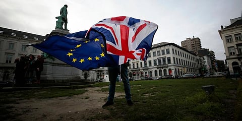 A man unfurls a Union and EU flag outside the European Parliament in Brussels. (File Photo | AP)