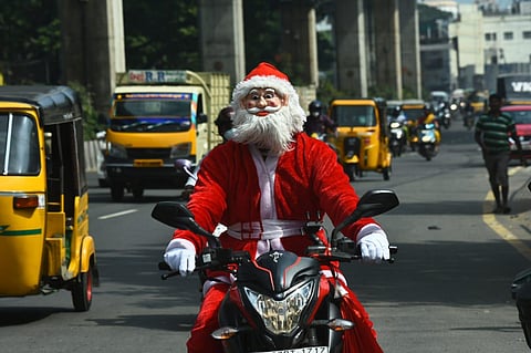 A man dressed as Santa riding a bike on GST road in Chennai. (Photo | Ashwin Prasath, EPS)