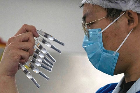 A worker inspects syringes of a vaccine for COVID-19 produced by Sinovac at its factory in Beijing. (File Photo | AP)