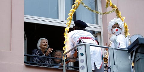 Artists, dressed as clowns, perform from a crane to entertain elderly people at a care home in Prague, Czech Republic. (Photo | AP)