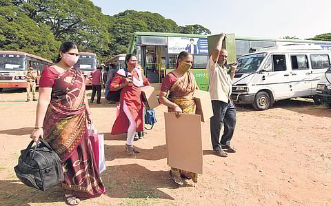 Polling officers deployed for the second phase of the Gram Panchayat elections leave a mustering centre in Mysuru on Saturday | Udayshankar S