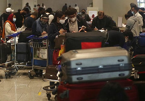 Passengers arriving from United Kingdom fill in forms with their travel details at Chhatrapati Shivaji Maharaj International Airport in Mumbai. (Photo | AP)