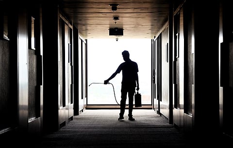 A hotel staff sanitizing the corridor of a hotel in Belagavi. (Photo | Ashishkrishna HP, EPS)
