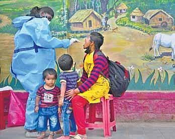 A health worker takes a swab sample from a passenger at Majestic Bust Stand, Bengaluru, on Monday | Ashish Krishna HP