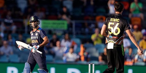 India's Shikhar Dhawan (L) walks away after he is bowled for 1 run by Australia's Mitchell Starc (R) during their T20 international cricket match at Manuka Oval, in Canberra. (Photo | AP)