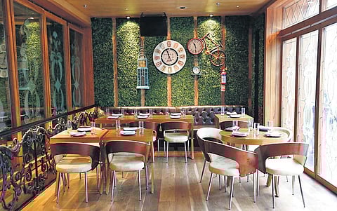 Kalra’s fixed table at Farzi Café, DLF Cyber Hub; (below) Kalra posing at the spot