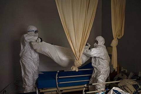 Wearing protective suits to prevent infection, mortuary workers remove the body of an elderly person who died of COVID-19 from a nursing home in Barcelona, Spain, Friday, Nov. 13, 2020. (Photo | AP)
