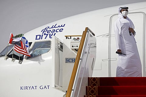 An official stands at the door of an Israeli El Al airliner after it landed in Abu Dhabi, United Arab Emirates. (Photo | AP)