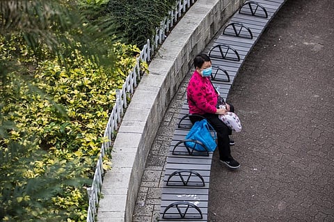 A woman wearing a protective face mask sits in a park in Hong Kong on February 9, 2020, as a preventative measure after a coronavirus outbreak which began in the Chinese city of Wuhan. (Photo | AFP)